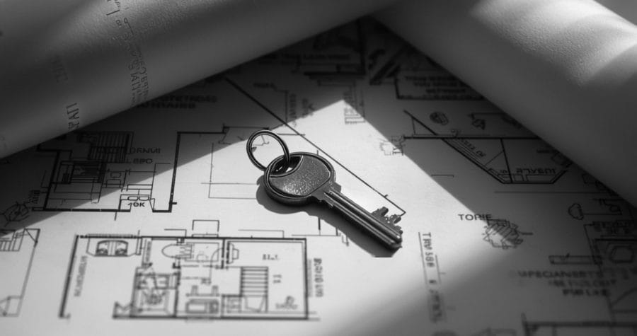 Llave sobre planos de una vivienda nueva en blanco y negro, alusiva a la exoneración del ITBI para primera vivienda en Panamá